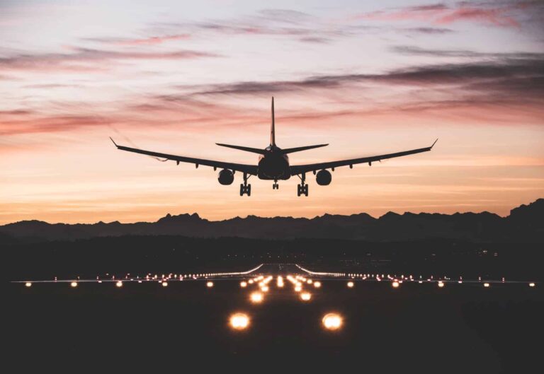 Aircraft landing on runway at sunset