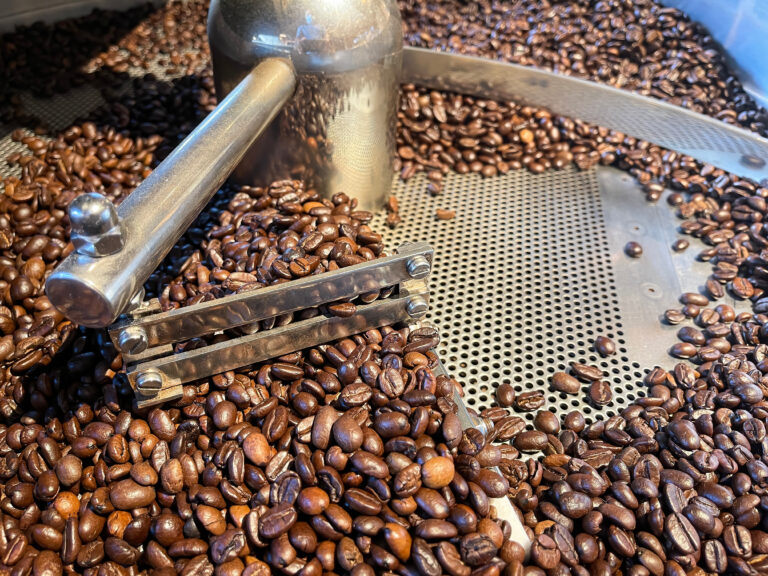 close up of roasted coffee beans in the sieve of a coffee roaster, coffee roasting process